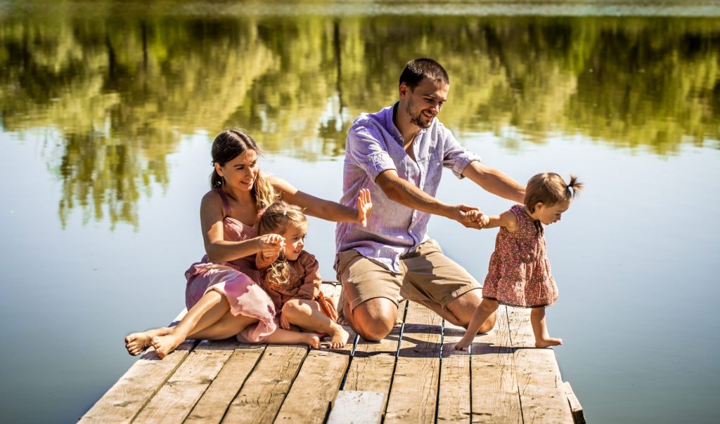 young family on pier near lake
